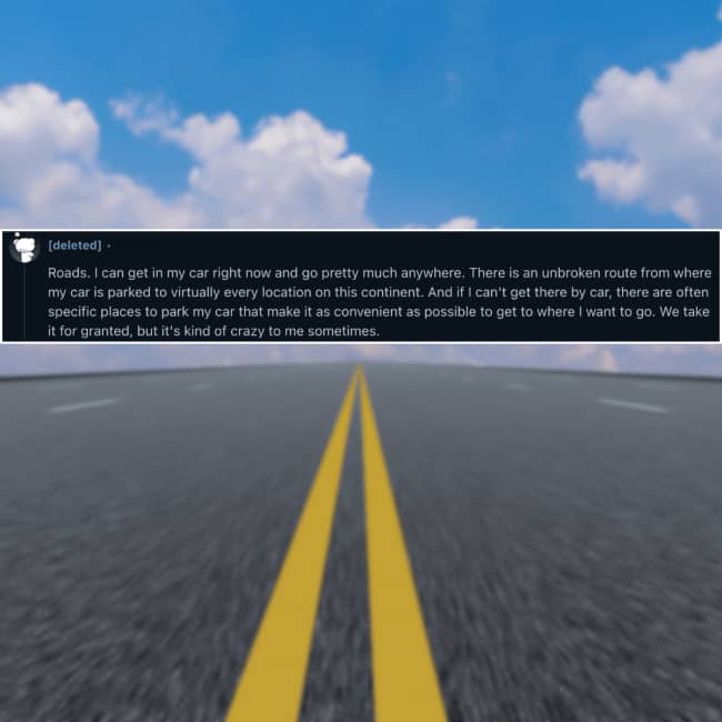 Low angle perspective of an empty two-lane asphalt highway beneath a blue cloudy sky.