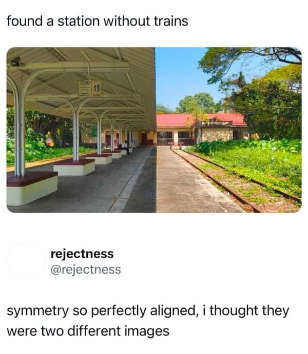 A perfectly symmetrical photo of an empty train station platform split down the middle by shadow.