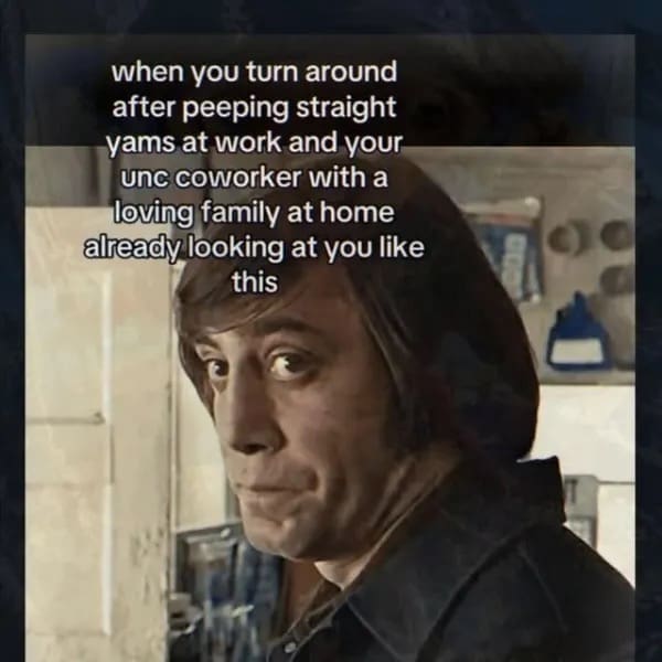 deeply specific funny meme utilizes a cinematic still of Javier Bardem as the chilling antagonist Anton Chigurh from No Country for Old Men. He is captured looking over his shoulder with an intensely judgmental and stern expression under the overlay text: "when you turn around after peeping straight yams at work and your unc coworker with a loving family at home already looking at you like this".