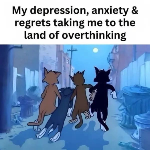 An intensely accurate funny meme captures a classic animation still from Tom and Jerry showing Tom Cat linking arms with three street cats as they stroll down a dark city alleyway under a full moon. The bold text overhead reinterprets their collective march, stating: "My depression, anxiety & regrets taking me to the land of overthinking."