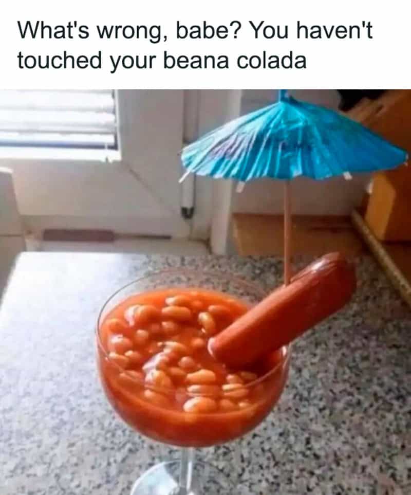 Cocktail glass filled with baked beans and hot dog as a funny fine dining mocktail meme.