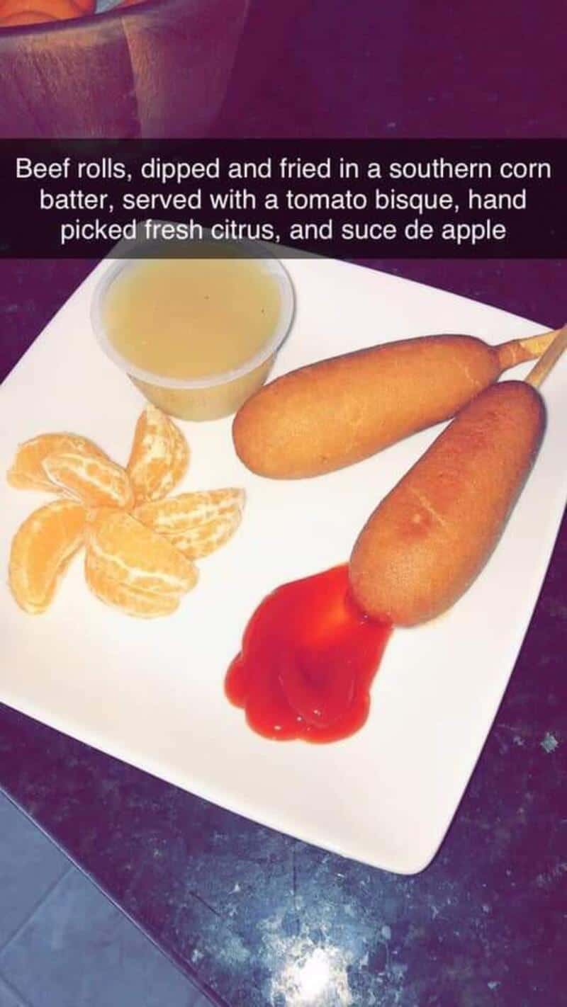 Corn dogs with ketchup splatter and fruit artfully arranged as haute cuisine in gourmet food meme.