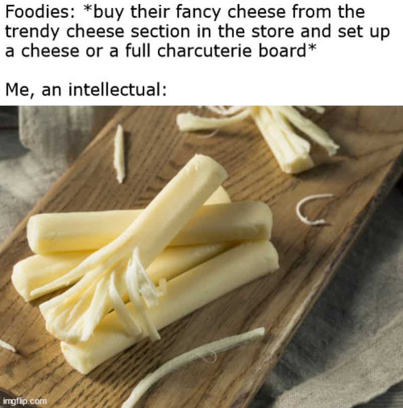 String cheese peeled apart on a wooden board parodying fancy charcuterie boards in food meme.