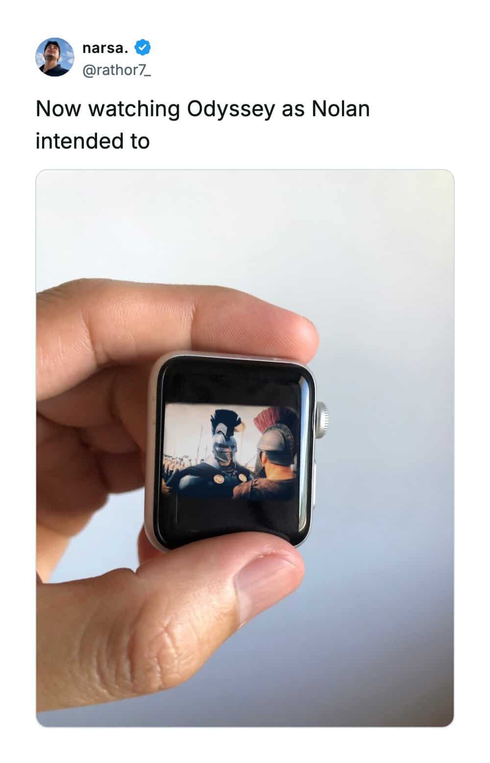 Hand holding an Apple Watch playing a cinematic ancient warrior movie on a miniature display.