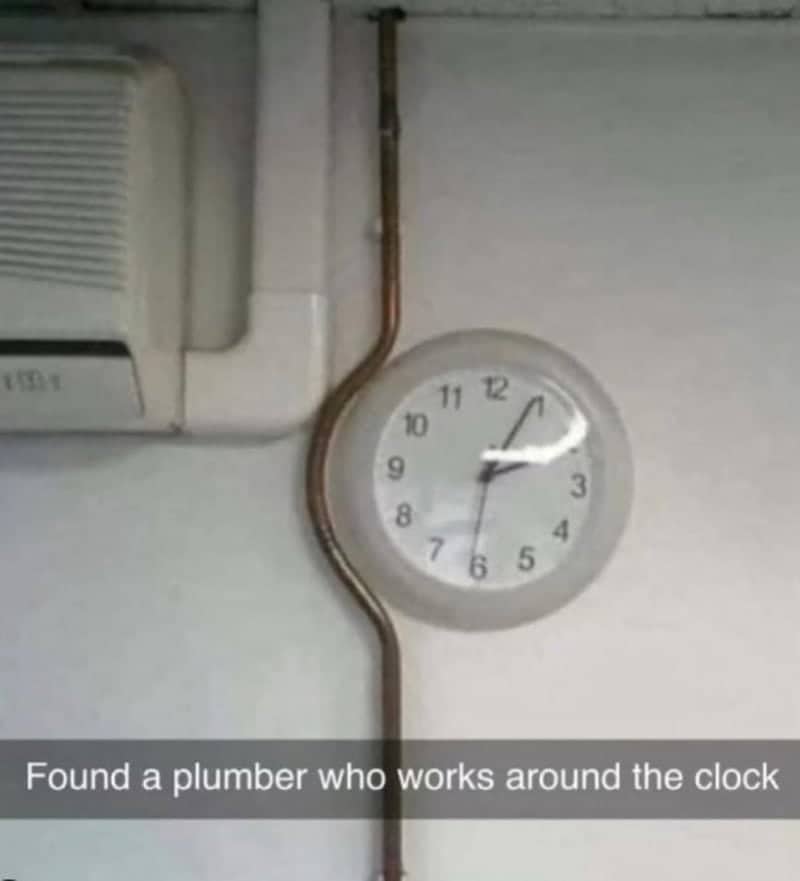 Copper water pipe installed with a bend around a round wall clock.
