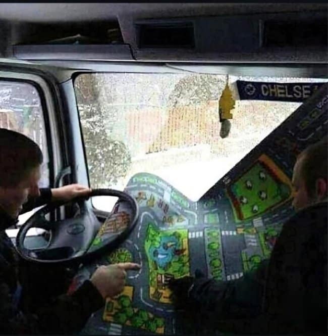 This brilliant road trip meme captures two truckers using a classic children's town play rug as a physical navigation map inside their cabin.