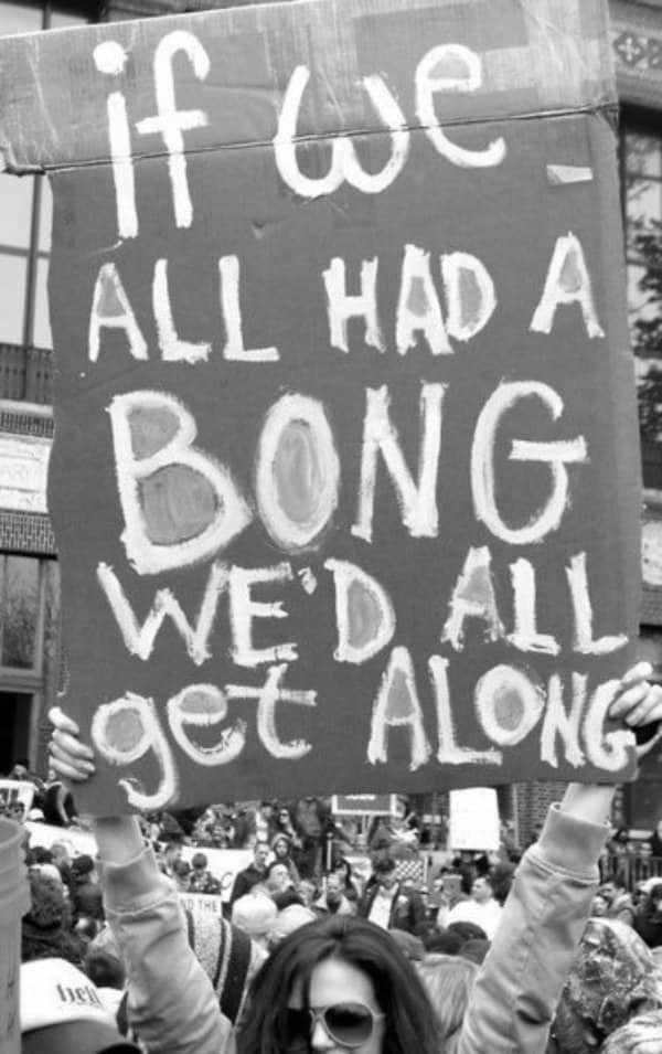 A black and white photo of a protest sign reading if we all had a bong we'd all get along.
