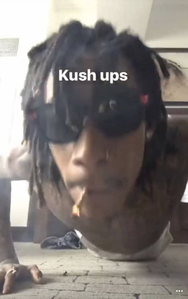 Wiz Khalifa smoking a joint while doing pushups on the floor with text kush ups.