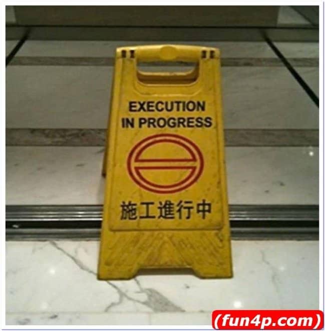 Yellow caution wet floor cone showing a terrifying translation fail reading "EXECUTION IN PROGRESS."